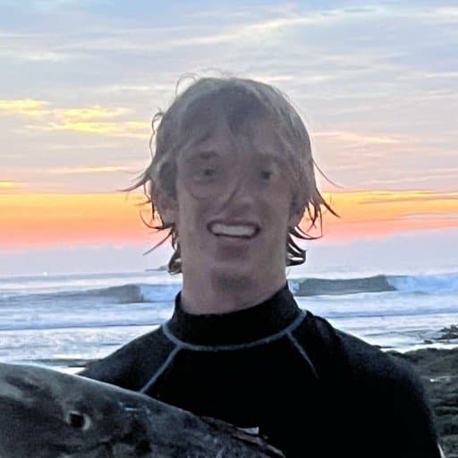 Noel in a wetsuit in the surf at sunset